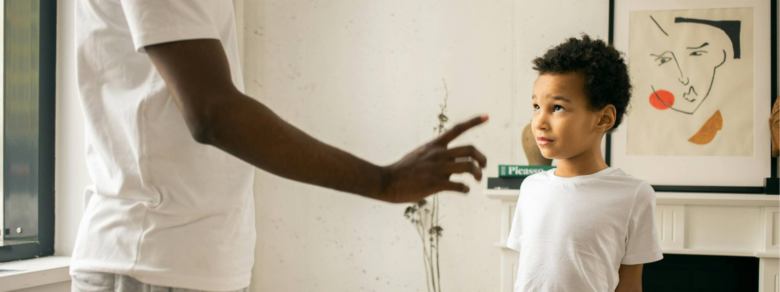 image of a father pointing a finger at a sheepish boy