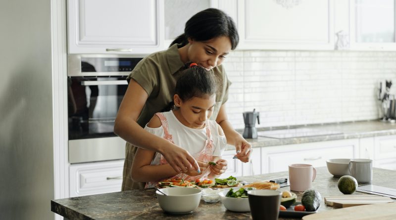 mother and daughter making food together