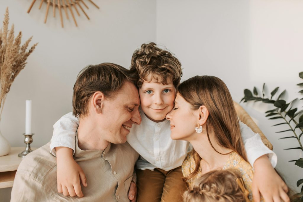 mother and father with preteen son hugging